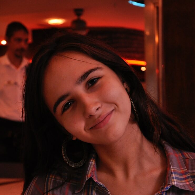 selective focus photography of smiling woman sitting at table