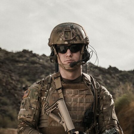 man in brown and black camouflage uniform holding rifle